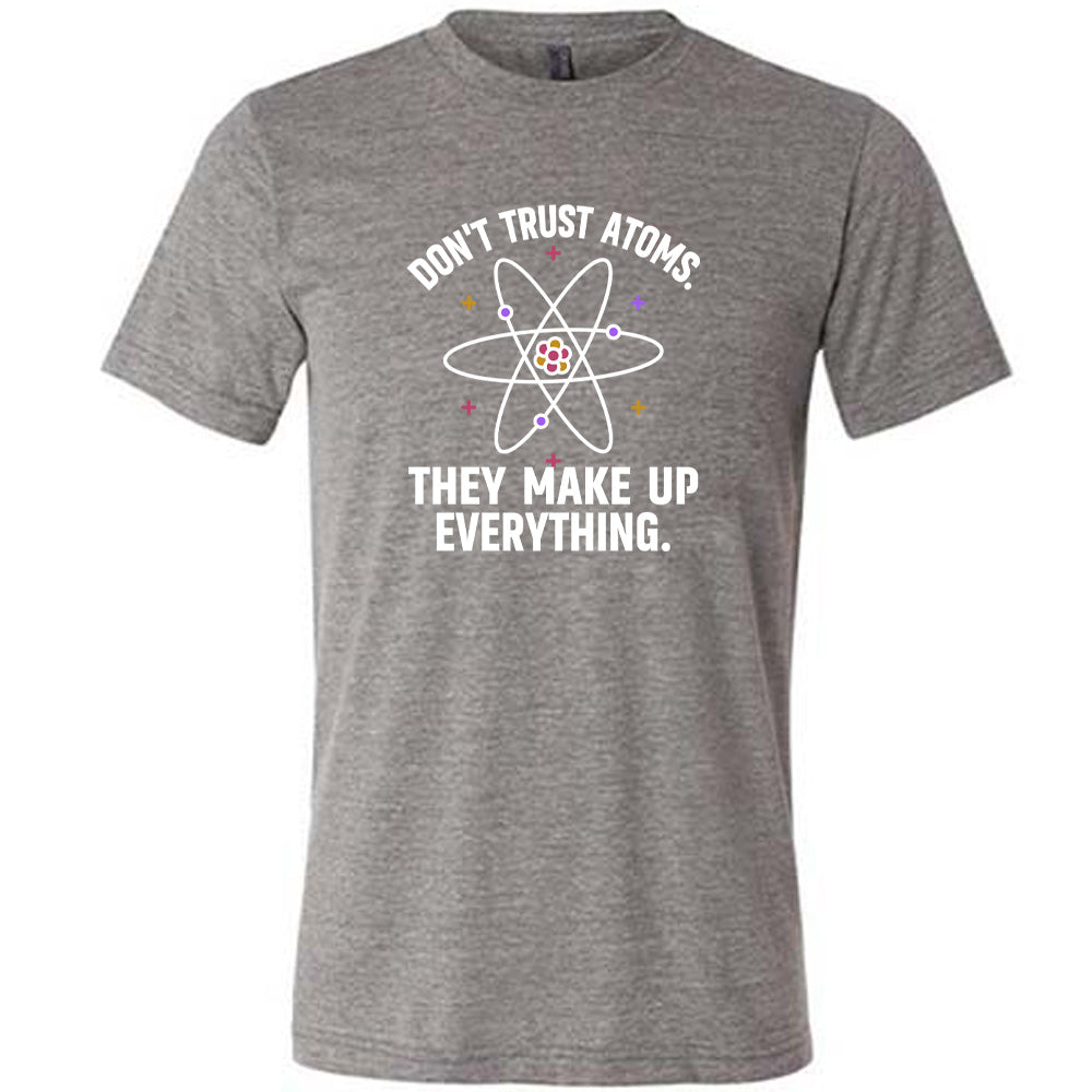Grey colored shirt with atom graphic on it that says "Don't Trust Atoms. They Make Up Everything."