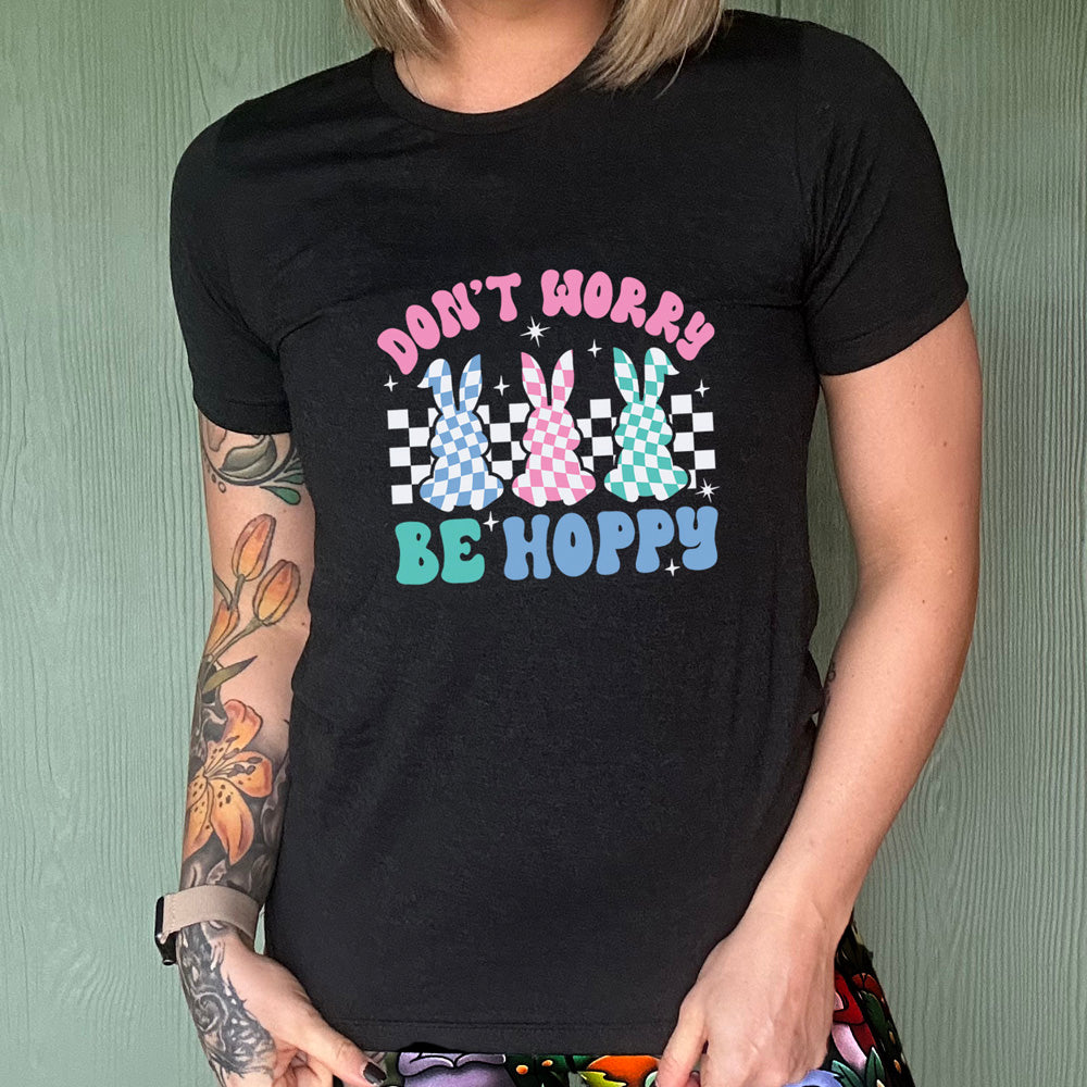 Black colored shirt with a checkered bunny graphic on it that says "Don't Worry Be Hoppy"