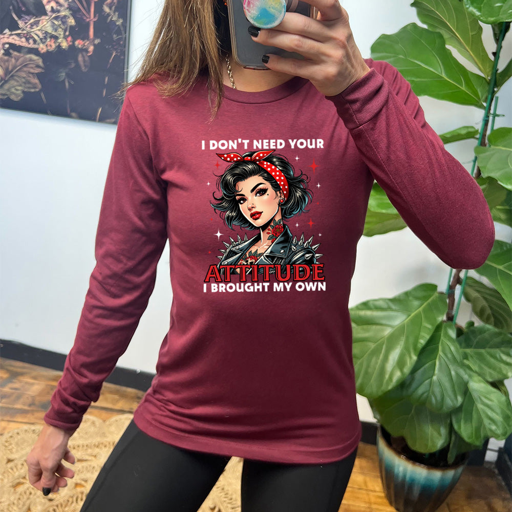 heather cardinal long sleeve shirt with the text "I Don't Need Your Attitude I Brought My Own" on it, with the graphic of a biker-style glamorous woman with a headband and tattoos