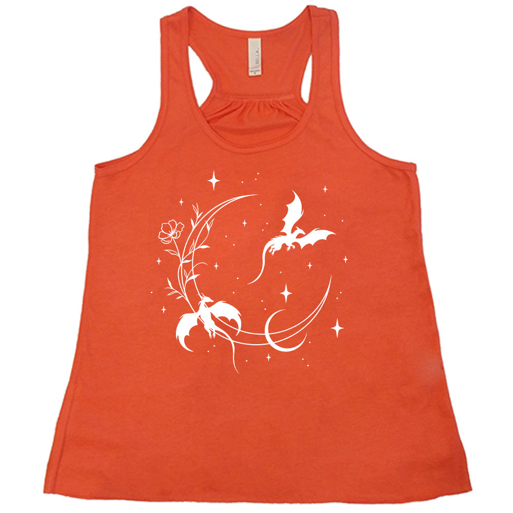 coral racerback flowy tank with the graphic of a large crescent moon, with a flower lining it, two dragons flying, another smaller moon, and many small stars