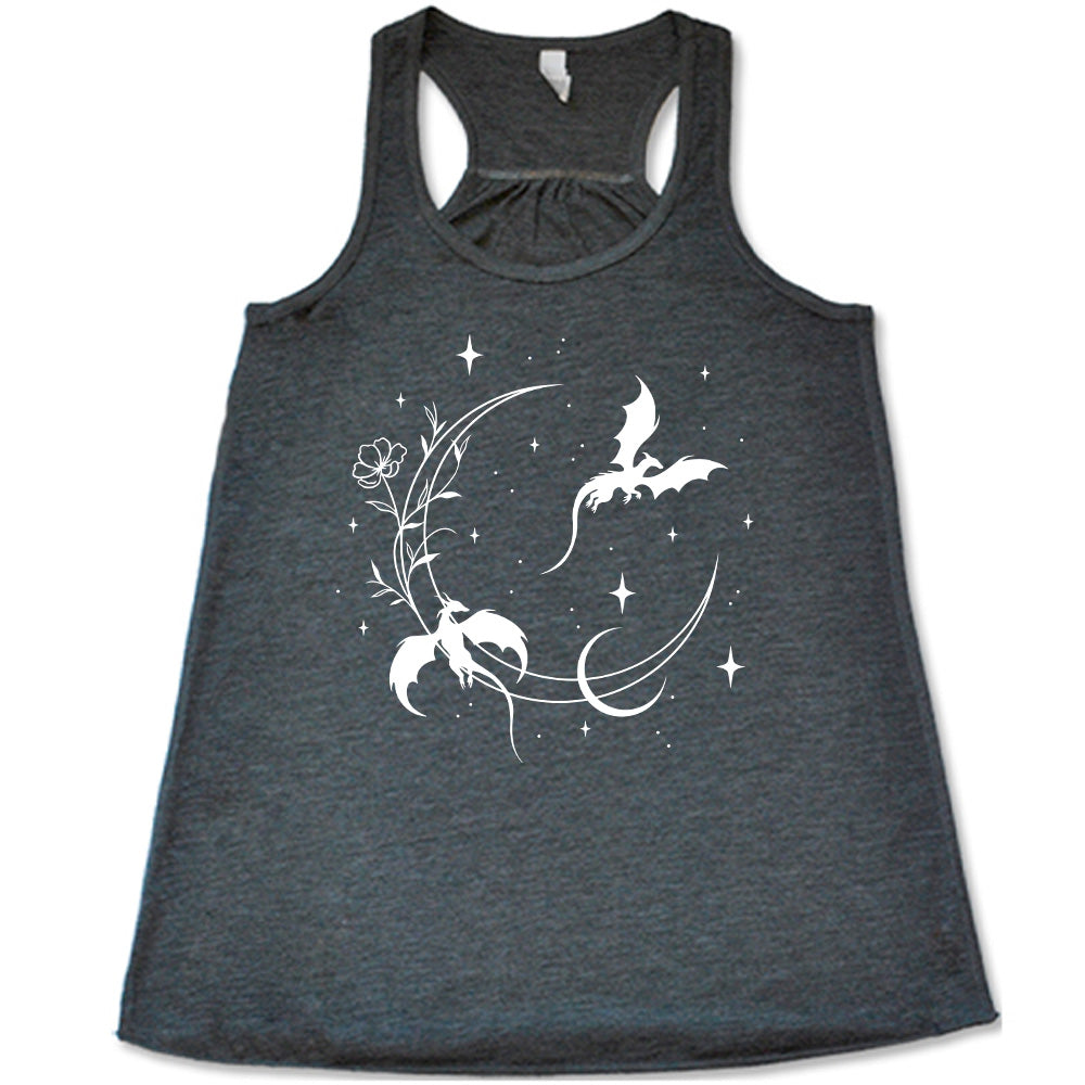grey racerback flowy tank with the graphic of a large crescent moon, with a flower lining it, two dragons flying, another smaller moon, and many small stars