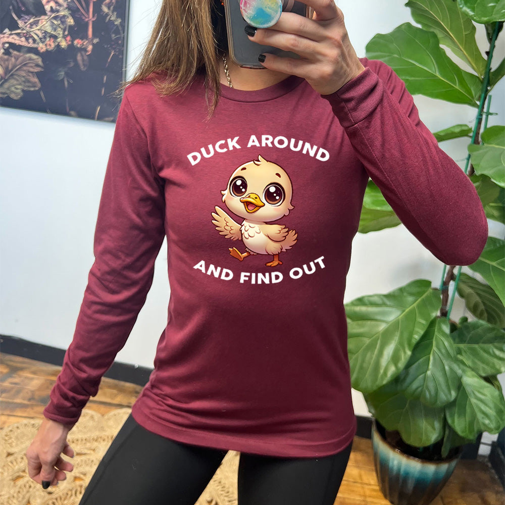 heather cardinal long sleeve tee with the text "Duck Around And Find Out" on it, with the graphic of a cartoon, innocent-looking duckling walking with one wing outstretched