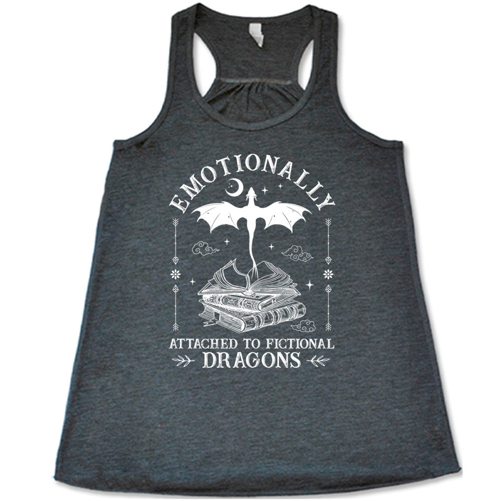 grey racerback flowy tank with the words "emotionally attached to fictional dragons" on it, with graphics of a stack of books, with a dragon flying out of the open book on top, few a few little clouds, a moon, some stars, and arrows and flowers