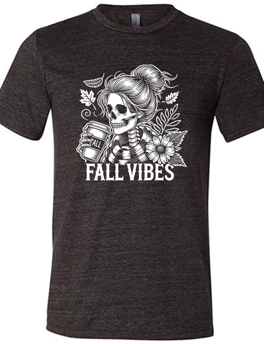 black unisex tee with the graphic of a skeletal woman, with her hair in a bun, holding a takeaway coffee cup labeled "fall", with a flower and leaves next to her, and the words underneath saying "fall vibes"