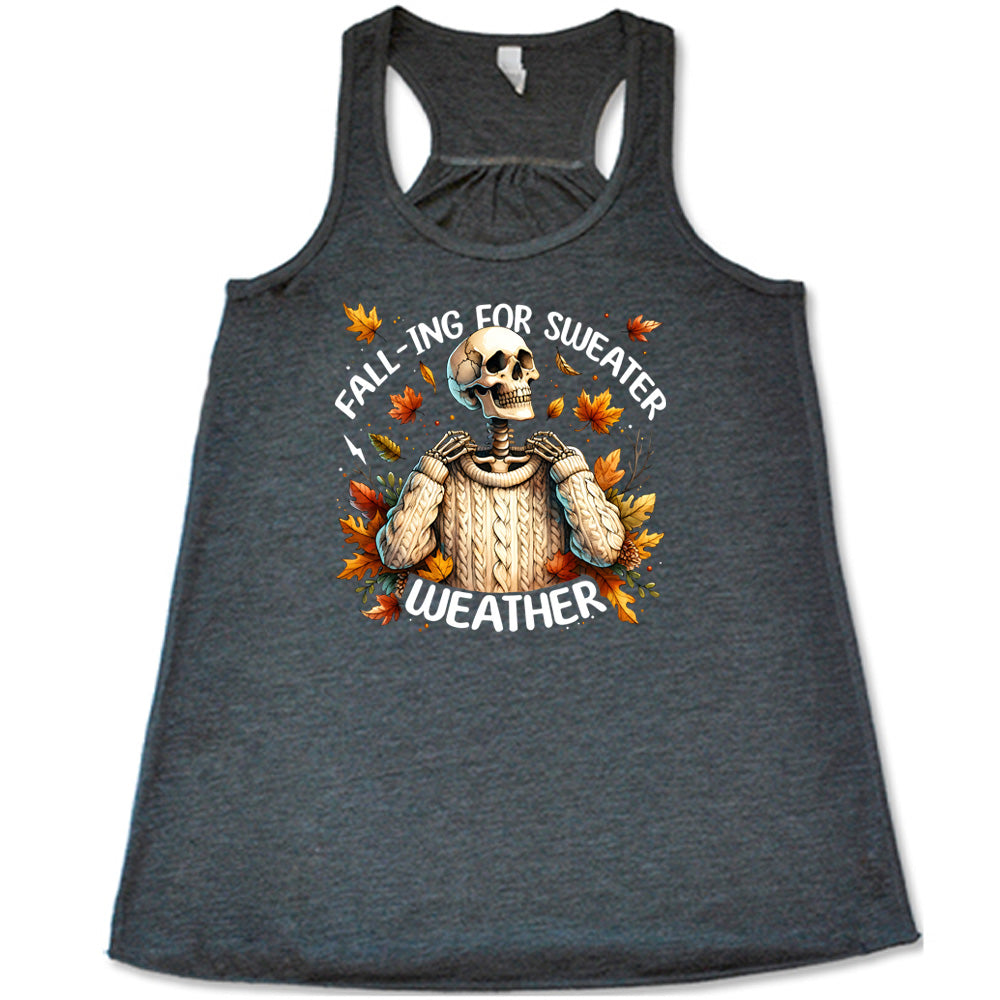Grey colored flowy tank with fall leaves and skeleton wearing a sweater graphic on it that says "Fall-ing For Sweater Weather"