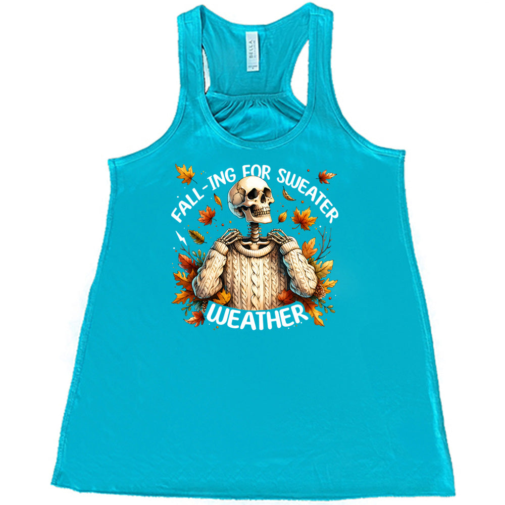 Teal colored flowy tank with fall leaves and skeleton wearing a sweater graphic on it that says "Fall-ing For Sweater Weather"