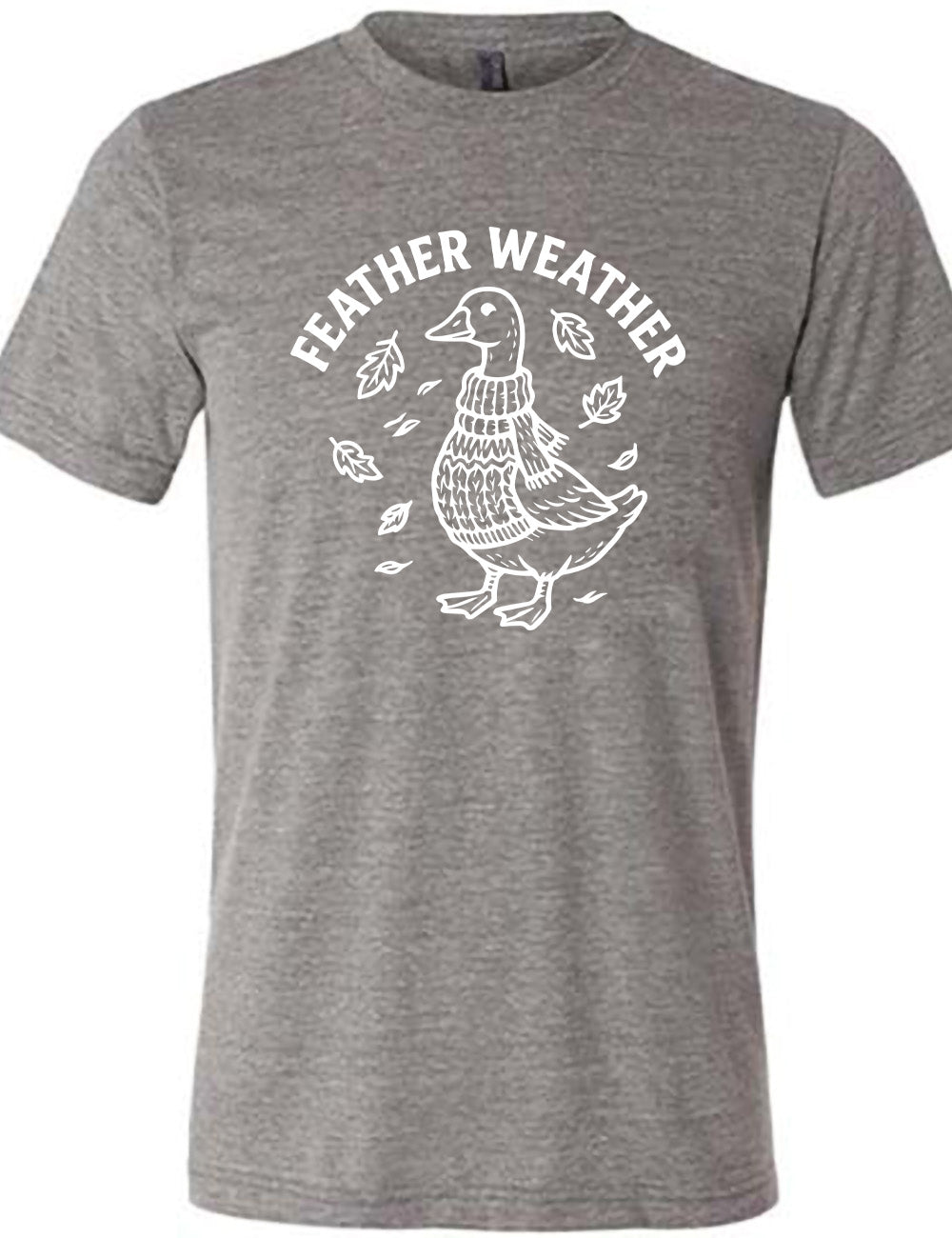 grey unisex tee with the graphic of a goose, wearing a scarf and sweater, surrounded by falling leaves, and the words arched over it saying "feather weather"