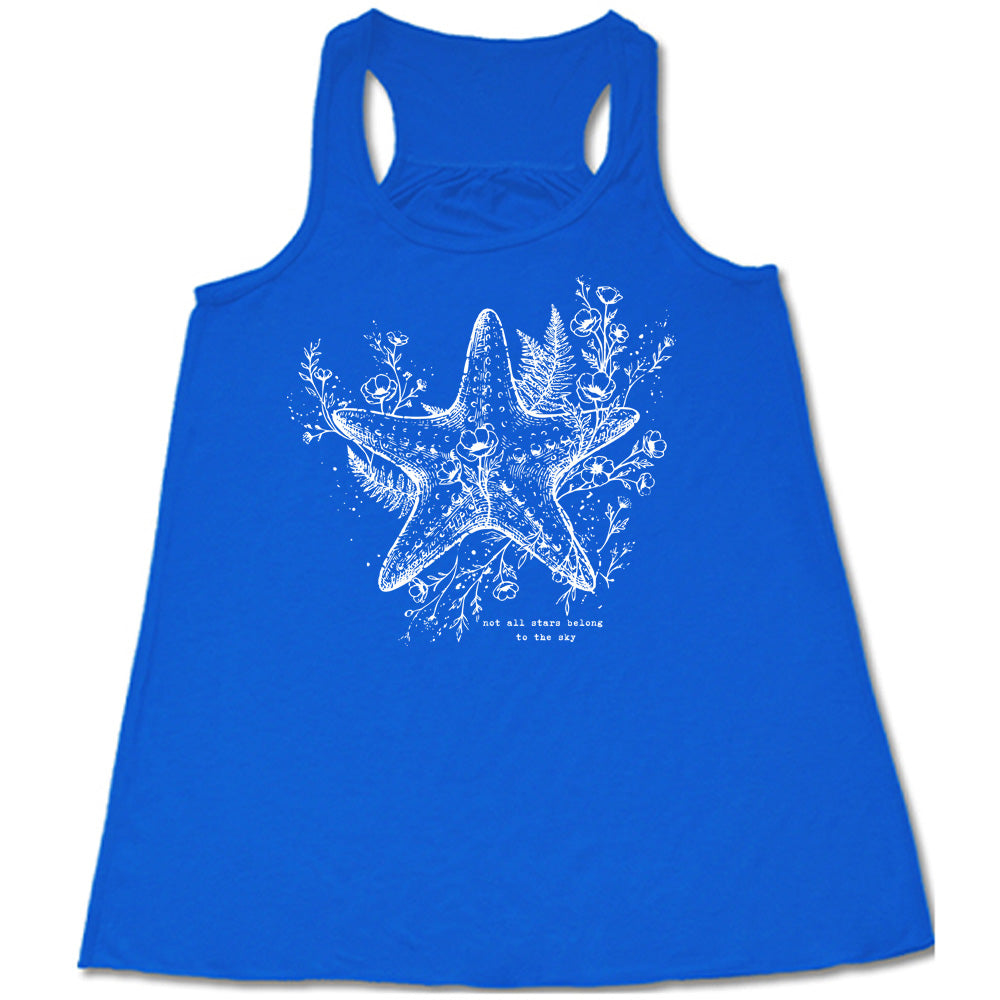 blue racerback flowy tank with the graphic of a very detailed starfish among sea plants and flowers, with little bubbles, and the small words underneath it all that say "not all stars belong to the sky"