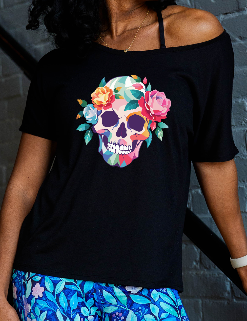 black slouchy tee with the colorful graphic of a skull, with flowers adorning it's head