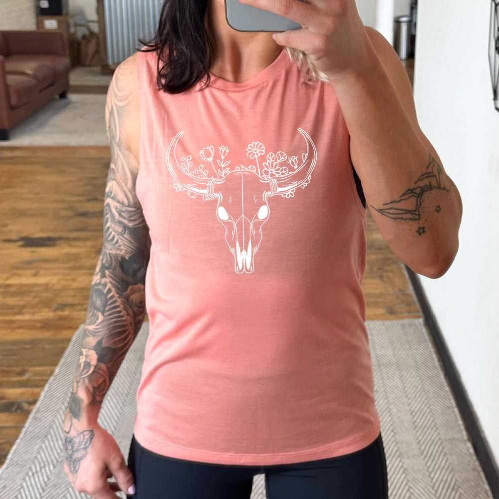 peach muscle tank with a floral cow skull graphic on it
