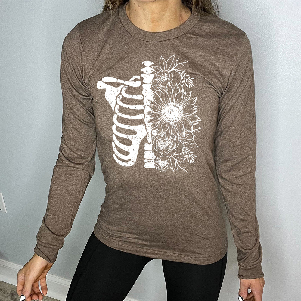 heather brown long sleeve shirt with the graphic of a skeletal ribcage, with half of it being made up of flowers