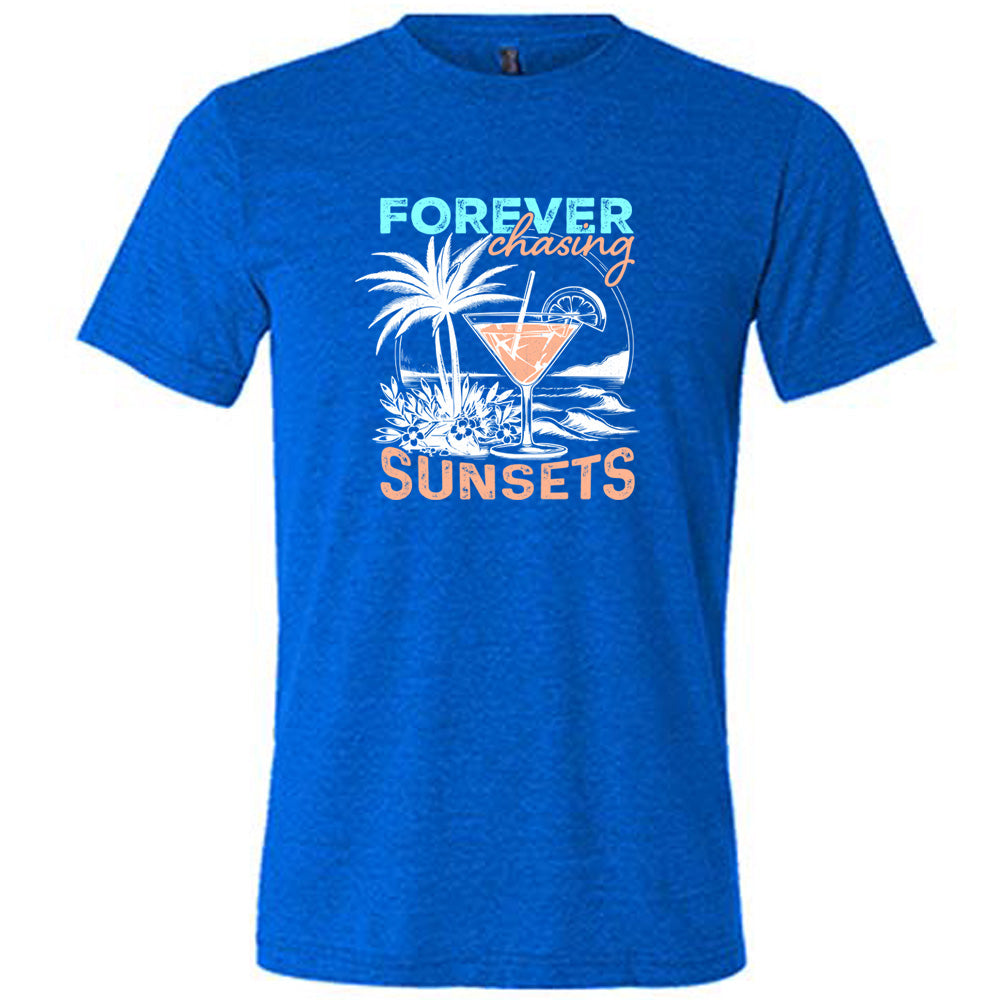 Blue colored shirt with a drink on the beach graphic on it that says "Forever Chasing Sunsets"