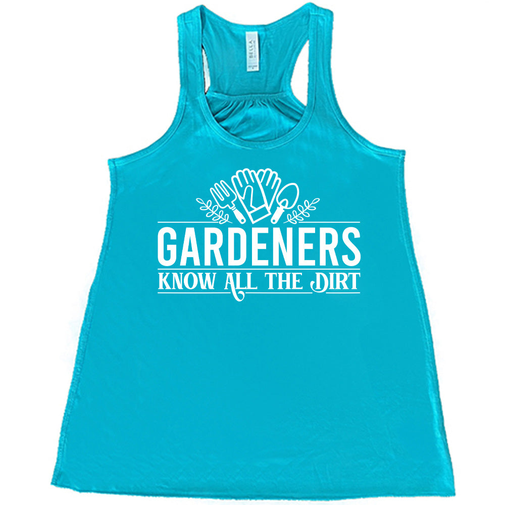 teal flowy racerback tank with the words "gardeners know all the dirt" on it, with the graphic of two gloves and two tools above the words
