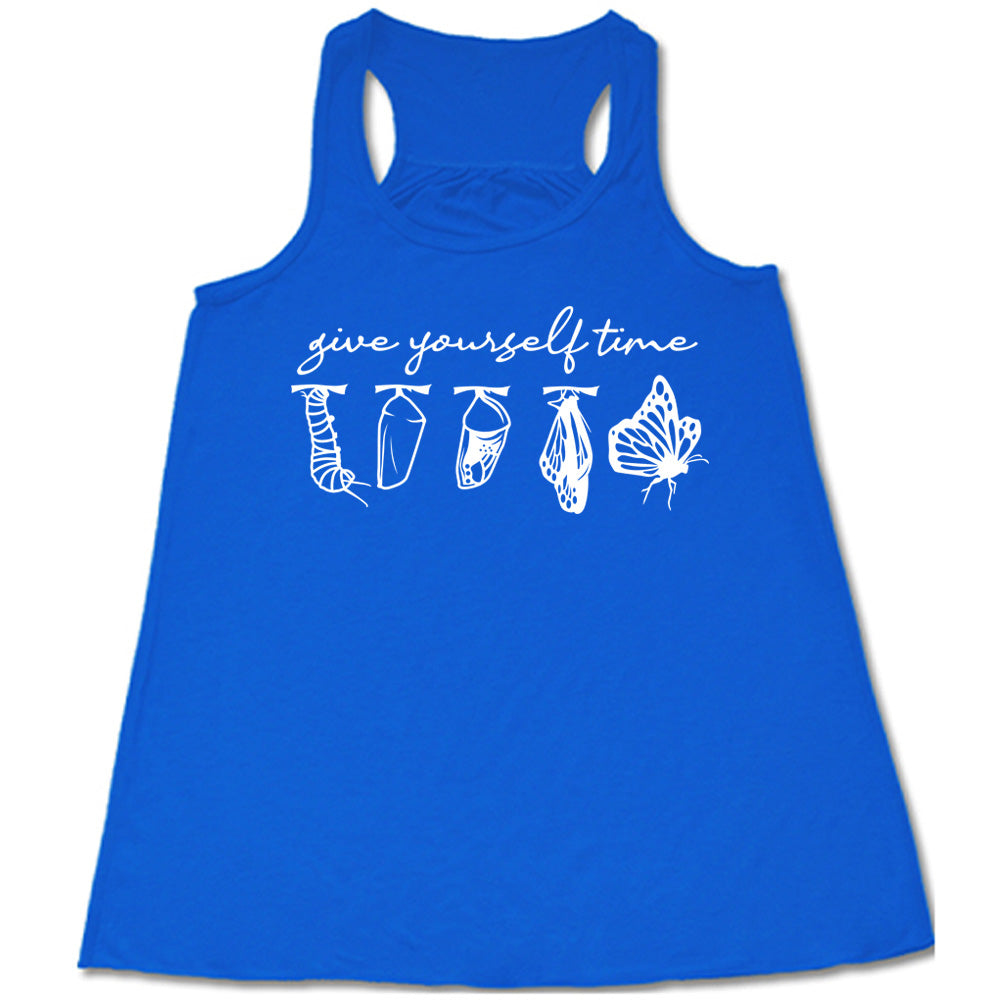 blue flowy racerback tank with the graphic of the complete metamorphosis of a butterfly, with words above it saying "give yourself time"