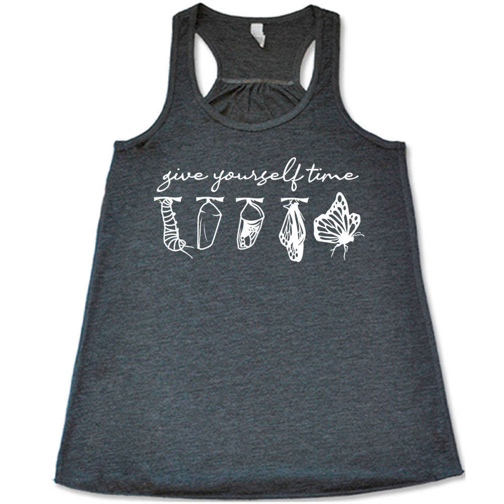 grey flowy racerback tank with the graphic of the complete metamorphosis of a butterfly, with words above it saying "give yourself time"