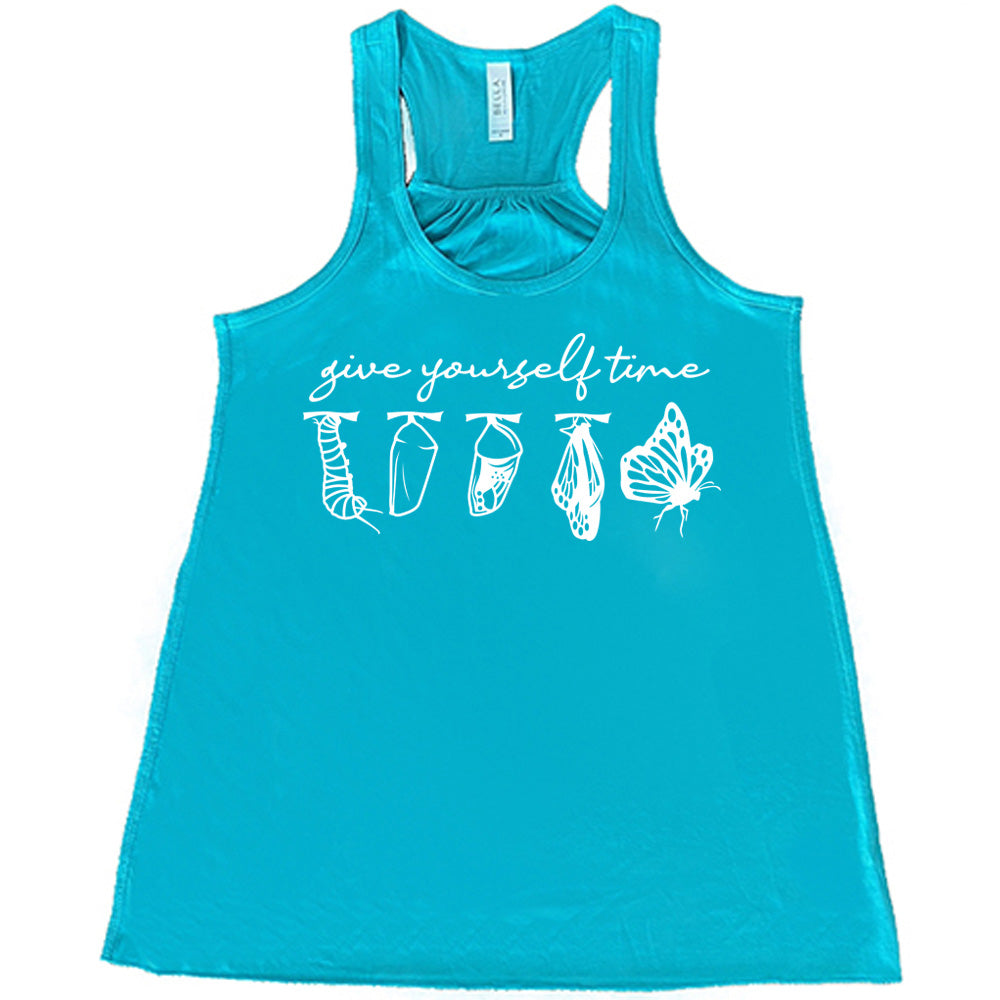 teal flowy racerback tank with the graphic of the complete metamorphosis of a butterfly, with words above it saying "give yourself time"