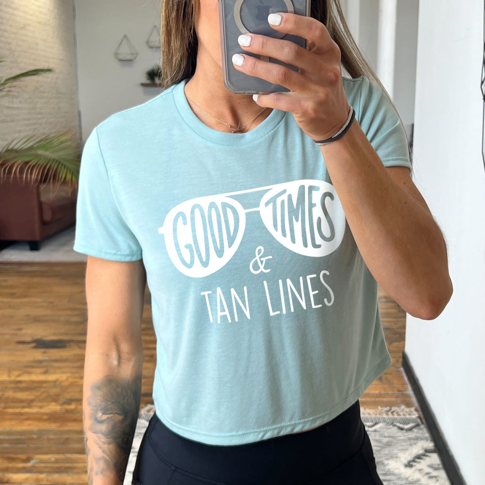 dusty blue cropped tee with a sunglasses graphic on it that says "Good Times & Tan Lines"