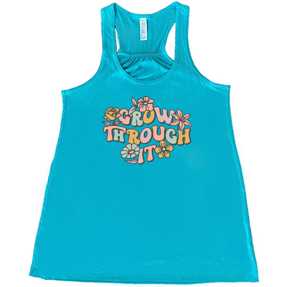 Teal colored flowy tank with a flower graphic on it that says "Grow Through It"