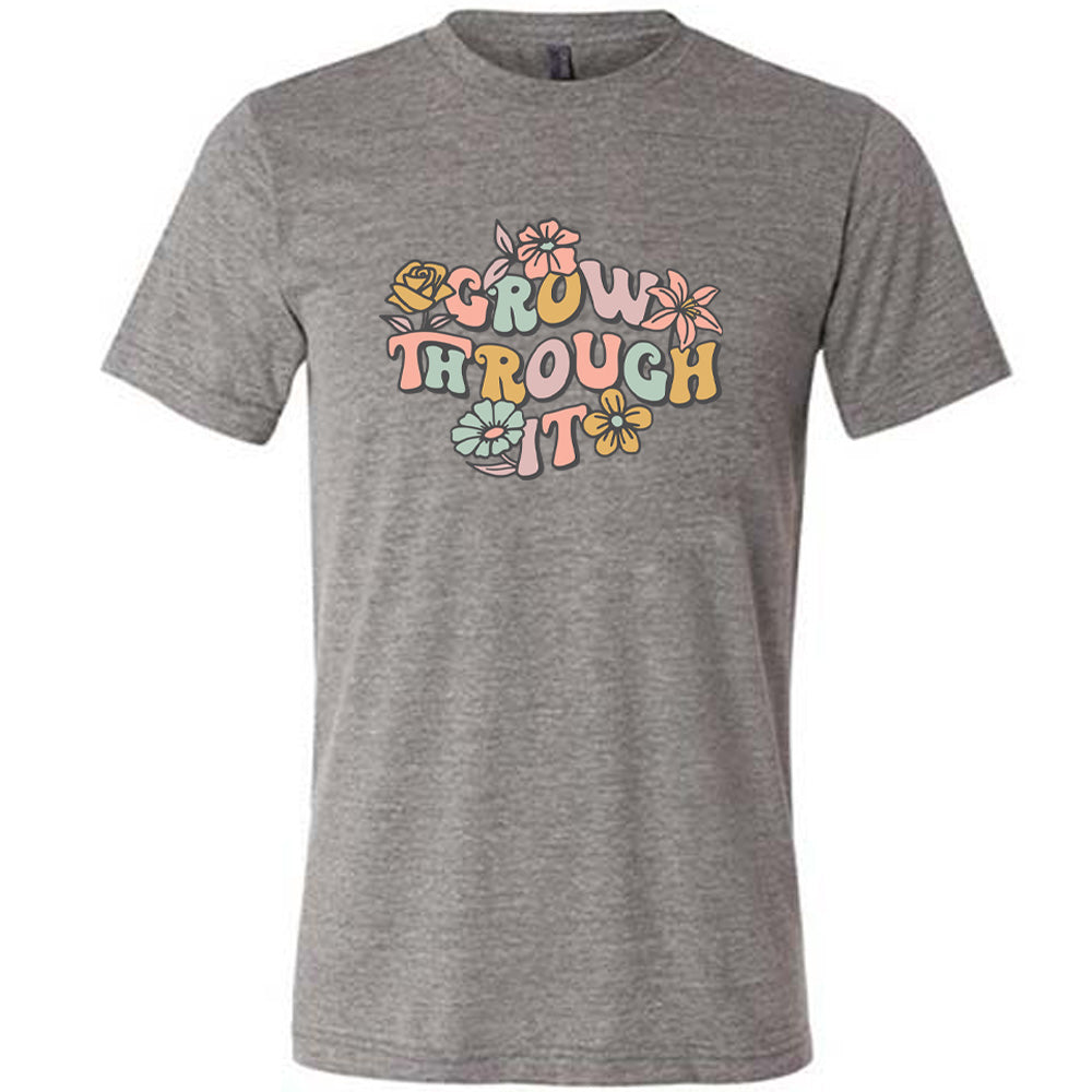 Grey colored shirt with a flower graphic on it that says "Grow Through It"