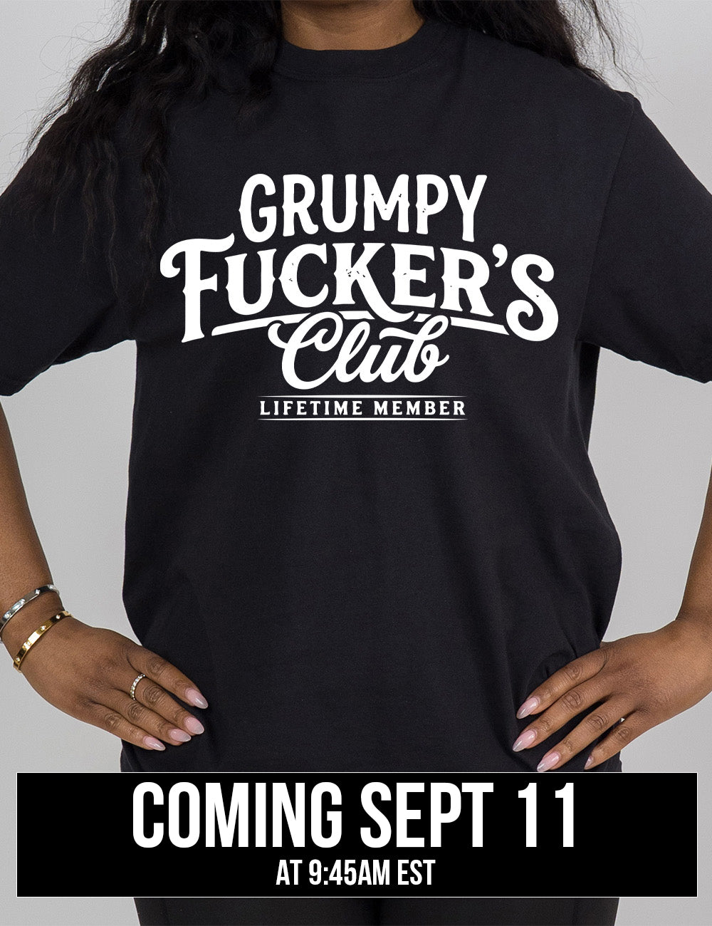 black modern tee with the words "grumpy fucker's club" on it, with smaller bannered words underneath saying "lifetime member", coming September 11th