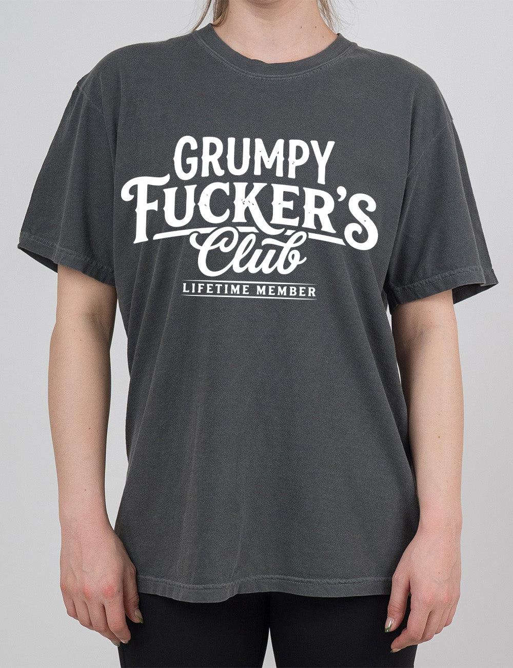 pepper modern tee with the words "grumpy fucker's club" on it, with smaller bannered words underneath saying "lifetime member"