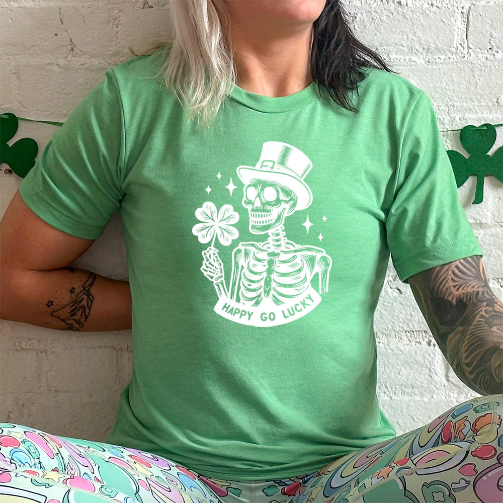 green shirt with a skeleton graphic and the text "happy go lucky" on it