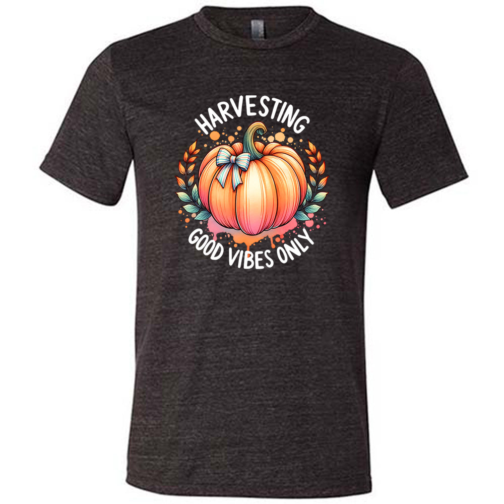 Black colored shirt with pumpkin graphic on it that says "Harvesting Good Vibes Only"