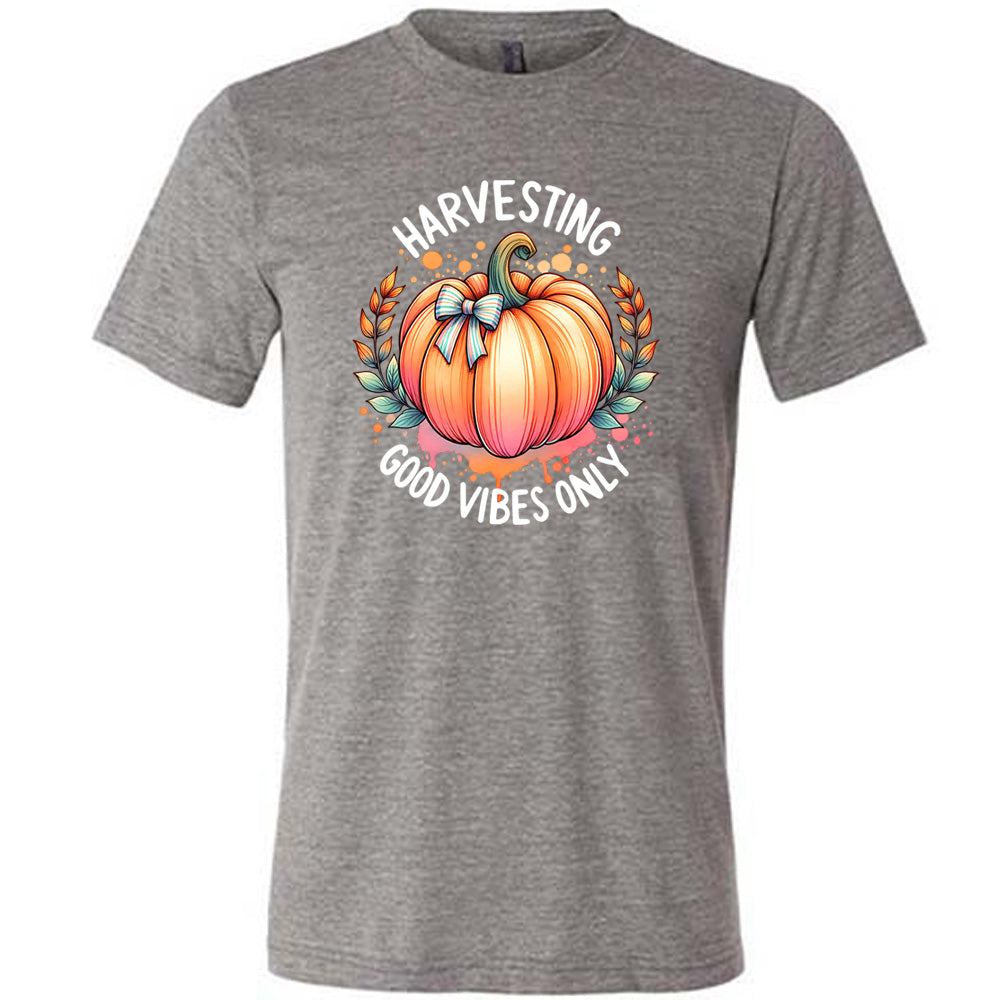 Grey colored shirt with pumpkin graphic on it that says "Harvesting Good Vibes Only"