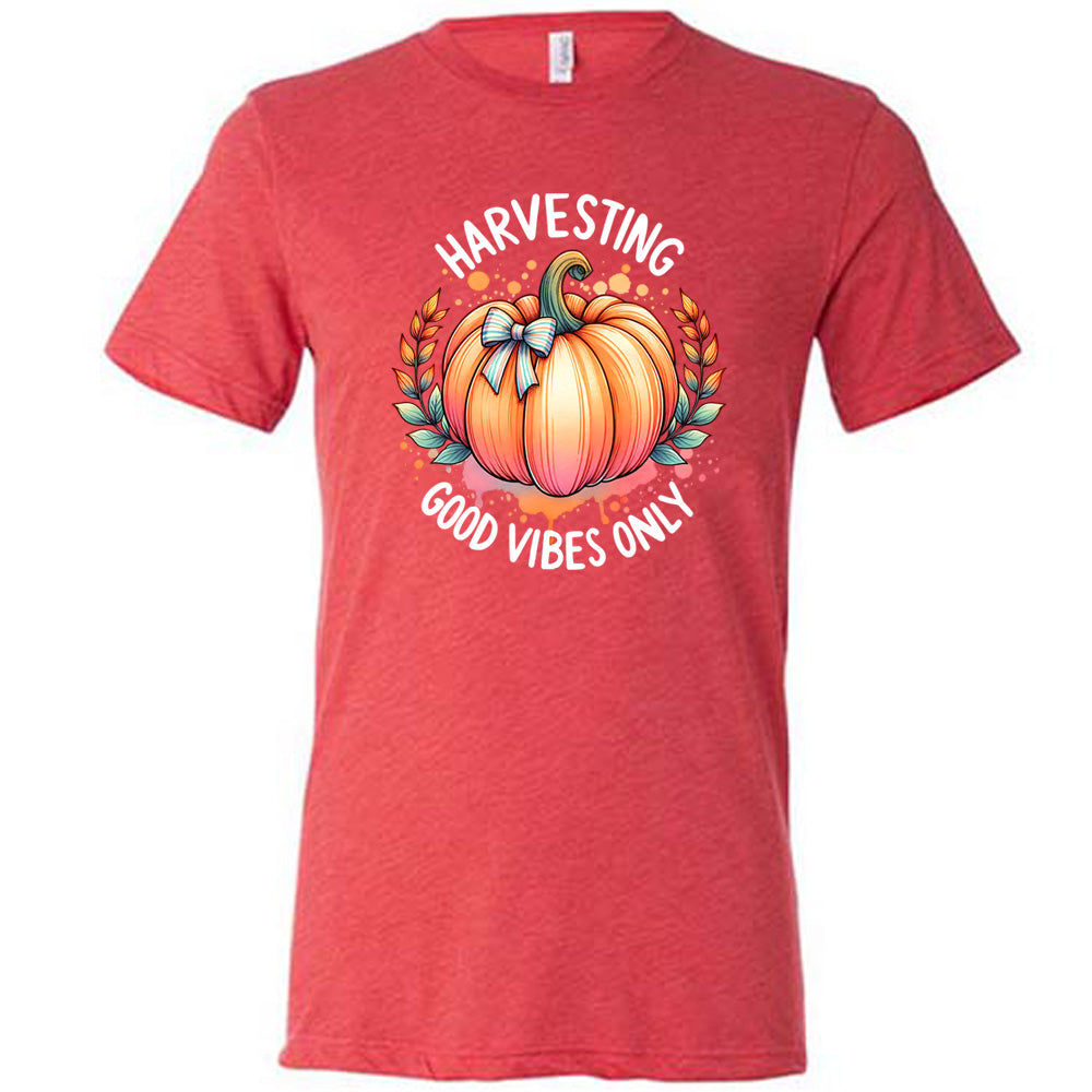 Red colored shirt with pumpkin graphic on it that says "Harvesting Good Vibes Only"