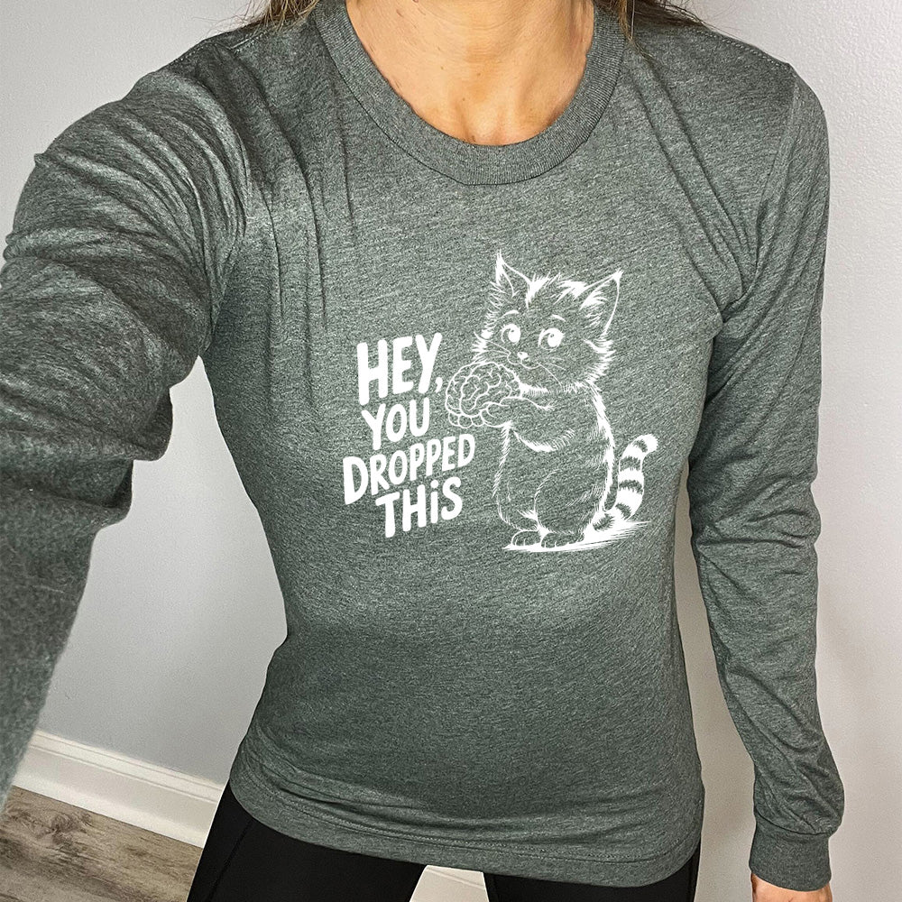 heather forest long sleeve with the words "Hey, you dropped this" and the graphic of a racoon holding a brain