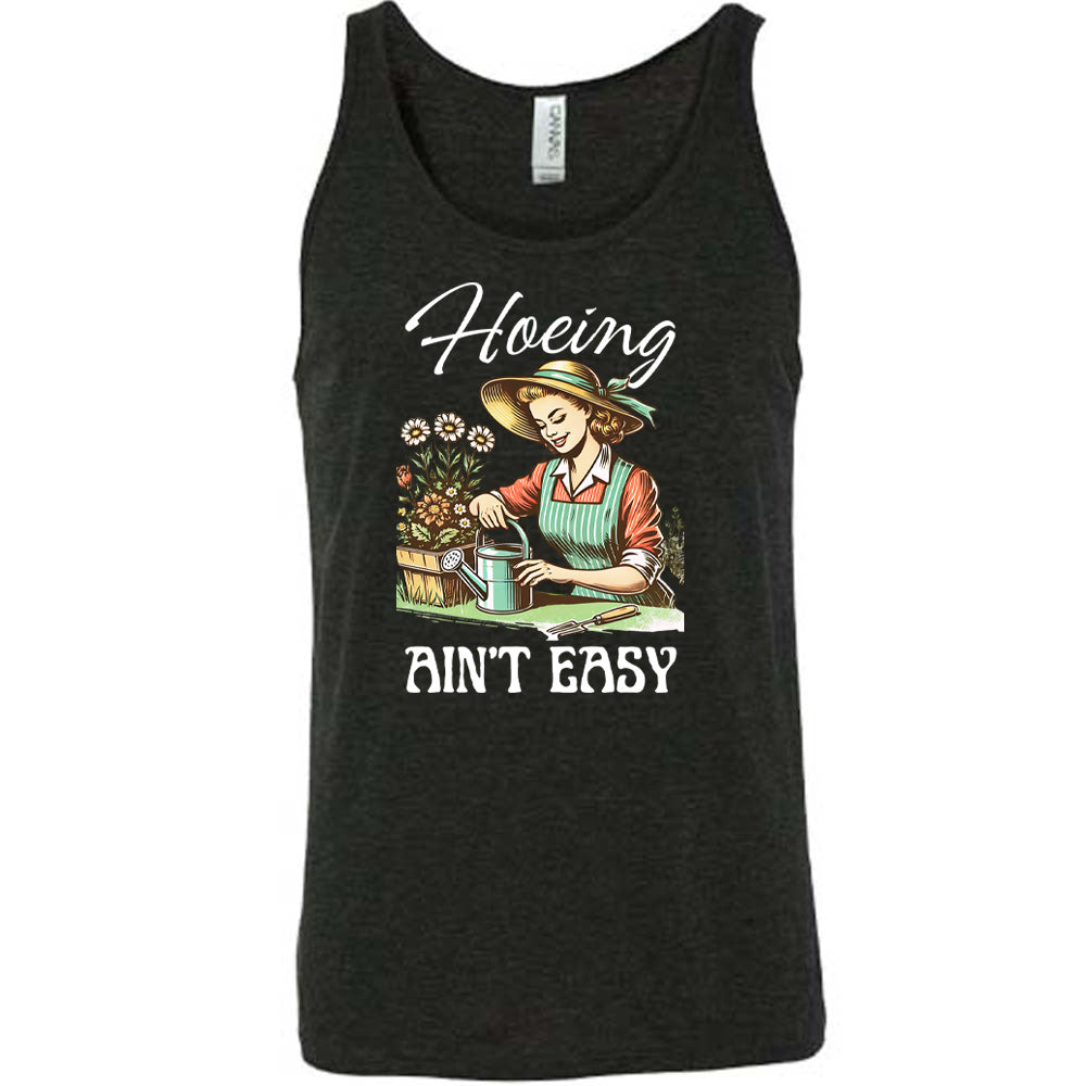 Black colored tank with a woman gardening graphic on it that says "Hoeing Ain't Easy"