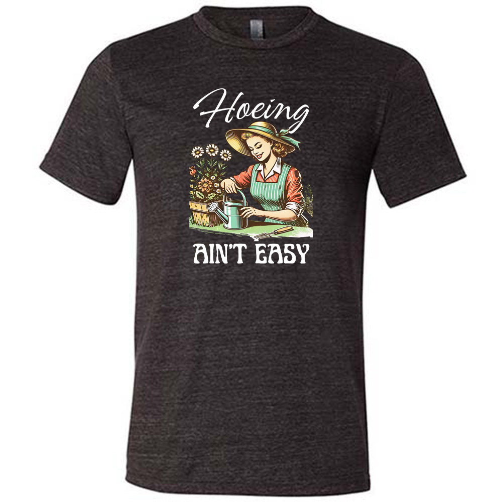 Black colored shirt with a woman gardening graphic on it that says "Hoeing Ain't Easy"