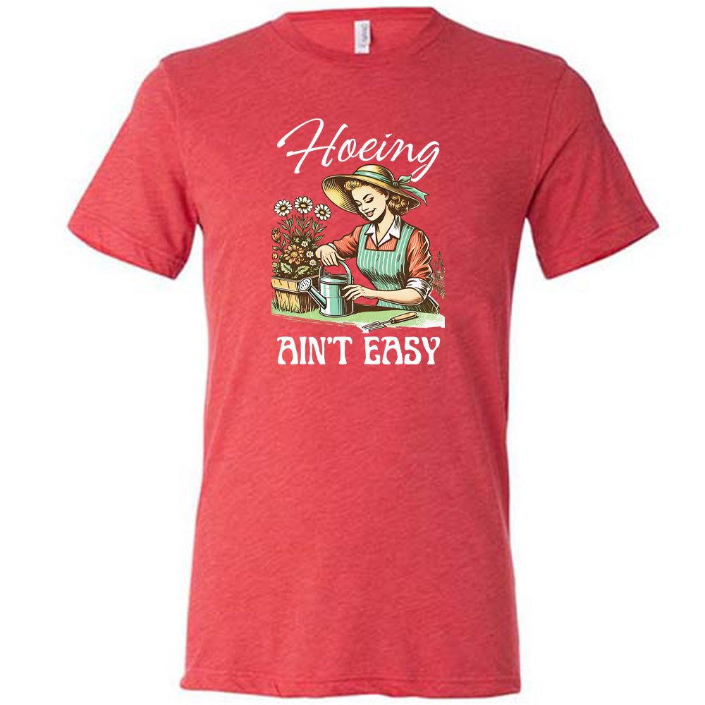 Red colored shirt with a woman gardening graphic on it that says "Hoeing Ain't Easy"