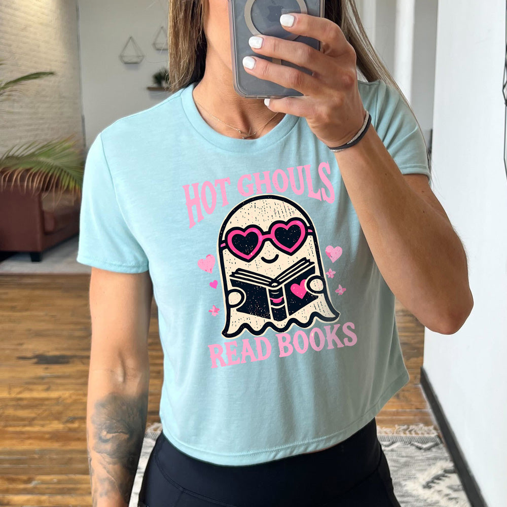Model wearing dusty blue colored cropped tee with ghost wearing heart-shaped glasses holding a book graphic on it that says "Hot Ghouls Read Books"