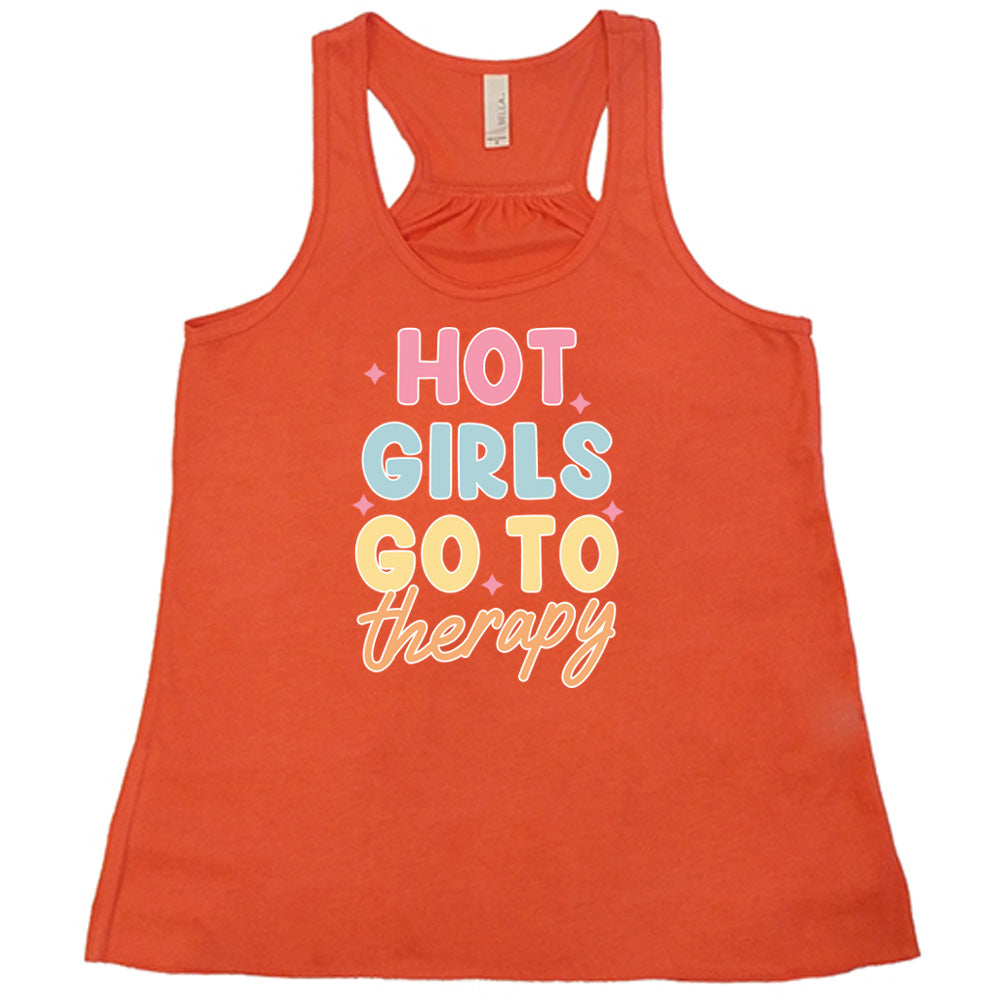Coral colored flowy tank with a sparkle graphic on it that says "Hot Girls Go To Therapy"