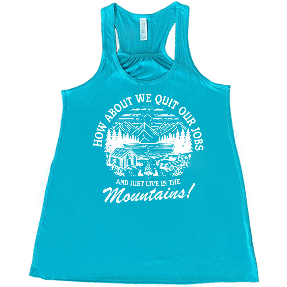 teal flowy tank with the words "How about we quit our jobs and just live in the mountains!" on it, with the graphic of a small house, a couple people sitting around a campfire, and an old car in the woods and mountains, with a sky and a couple stars and the moon