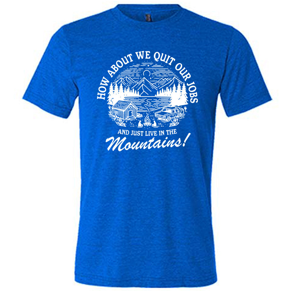 blue unisex tee with the words "How about we quit our jobs and just live in the mountains!" on it, with the graphic of a small house, a couple people sitting around a campfire, and an old car in the woods and mountains, with a sky and a couple stars and the moon