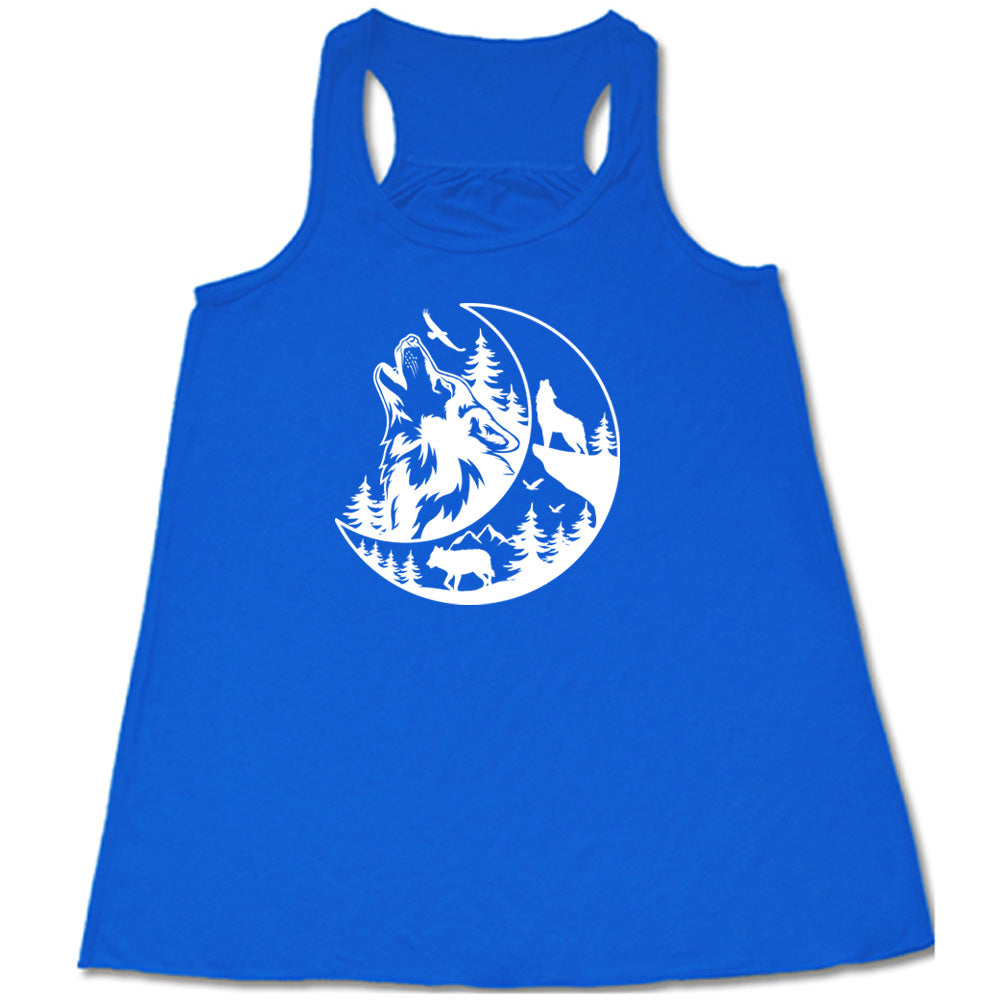 Blue colored flowy tank with a wolf howling at the moon in the forest graphic on it