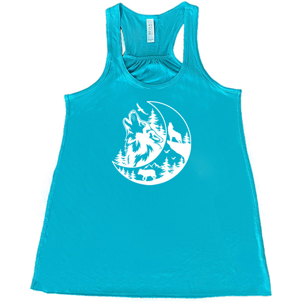 Teal colored flowy tank with a wolf howling at the moon in the forest graphic on it