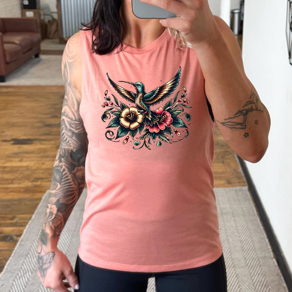 peach muscle tank with the graphic of a colorful hummingbird flying, with a colorful flower bouquet