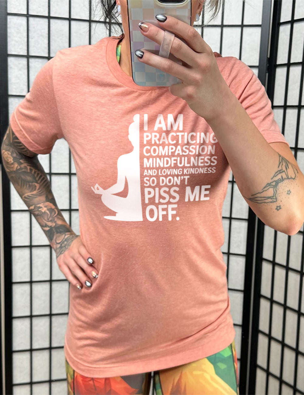 sunset unisex tee with the graphic of a woman's silhouette (only one half of it) next to the words saying "I am practicing compassion mindfulness and loving kindness so don't piss me off."