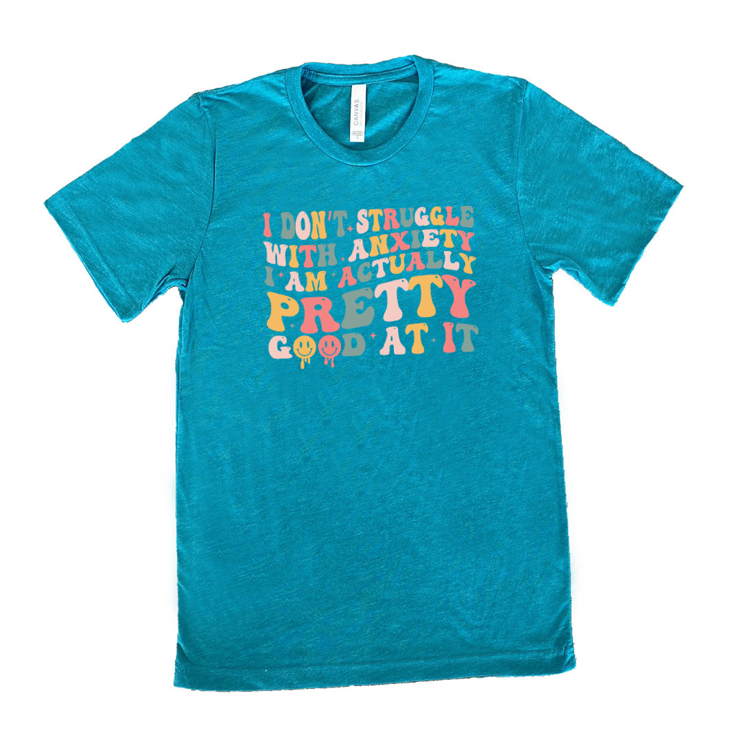 Teal colored shirt with a graphic on it that says "I Don't Struggle With Anxiety, I Am Actually Pretty Good At It"