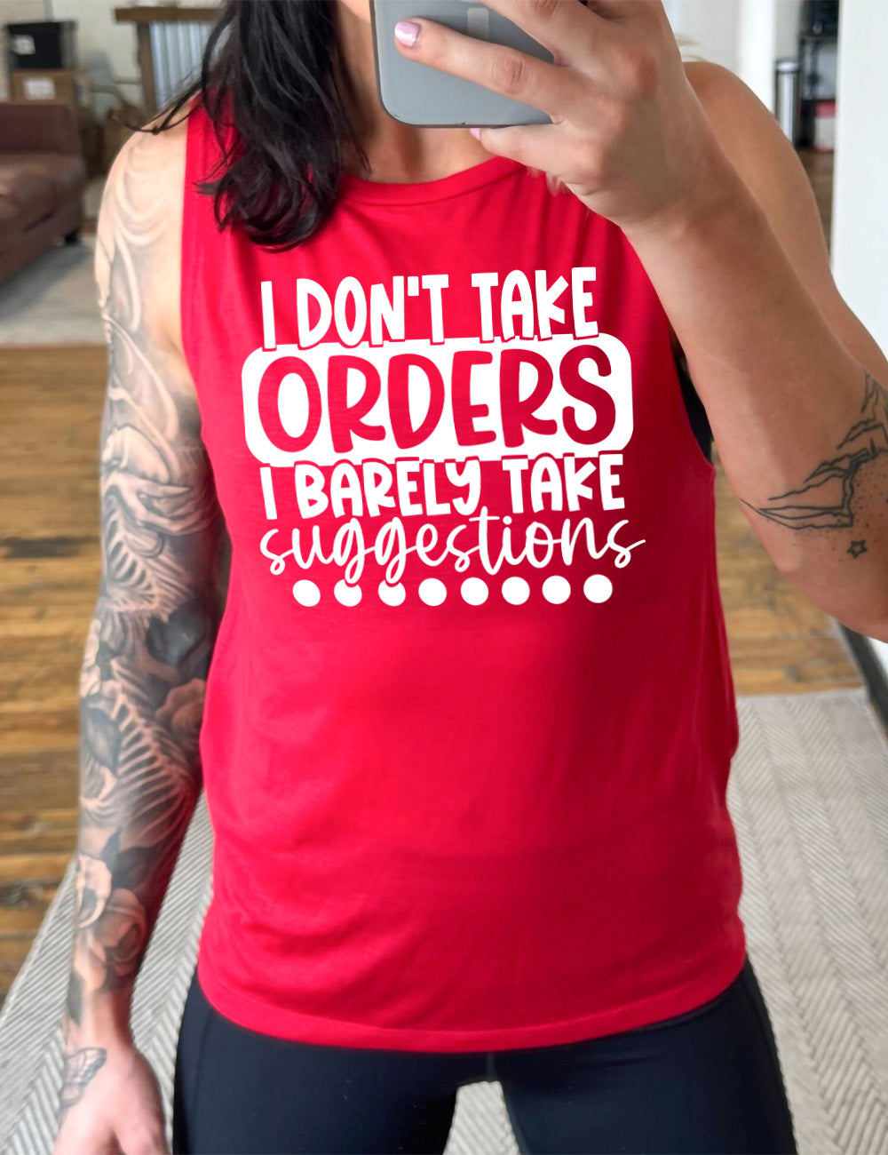 red muscle tank with the words "I don't take orders I barely take suggestions" on it, with a row of dots underneath