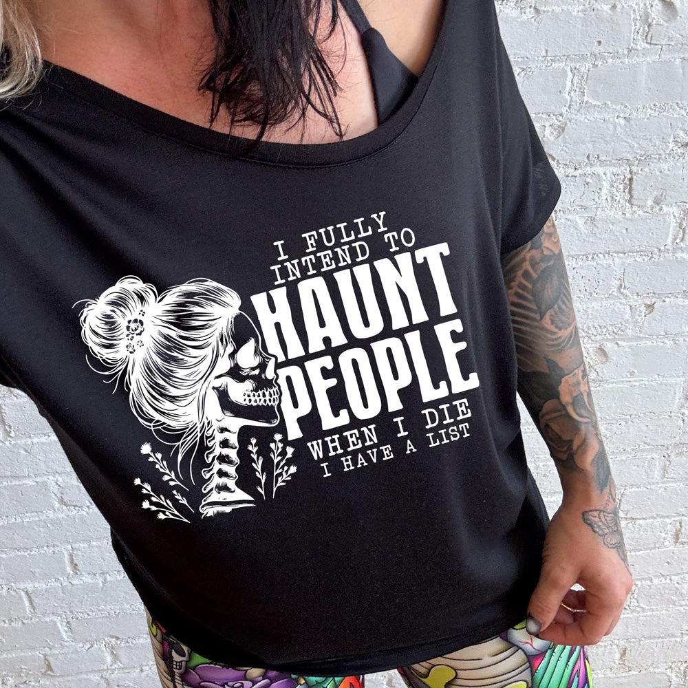 shirt with smiling female skeleton graphic on it that says "I Fully Intend To Haunt People When I Die I Have A List"