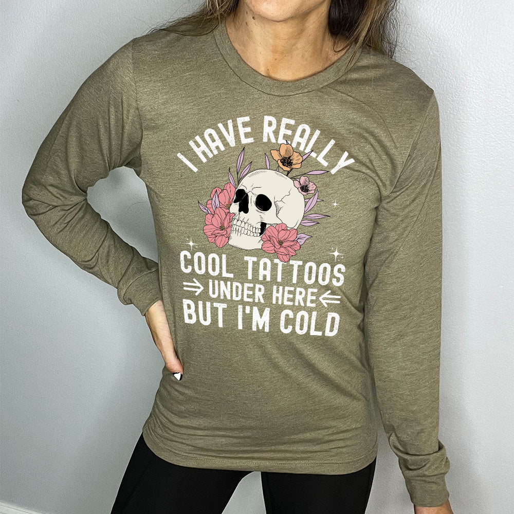 heather olive long sleeve with the words "I have really cool tattoos under here but I'm cold" with the image of a skull in flowers