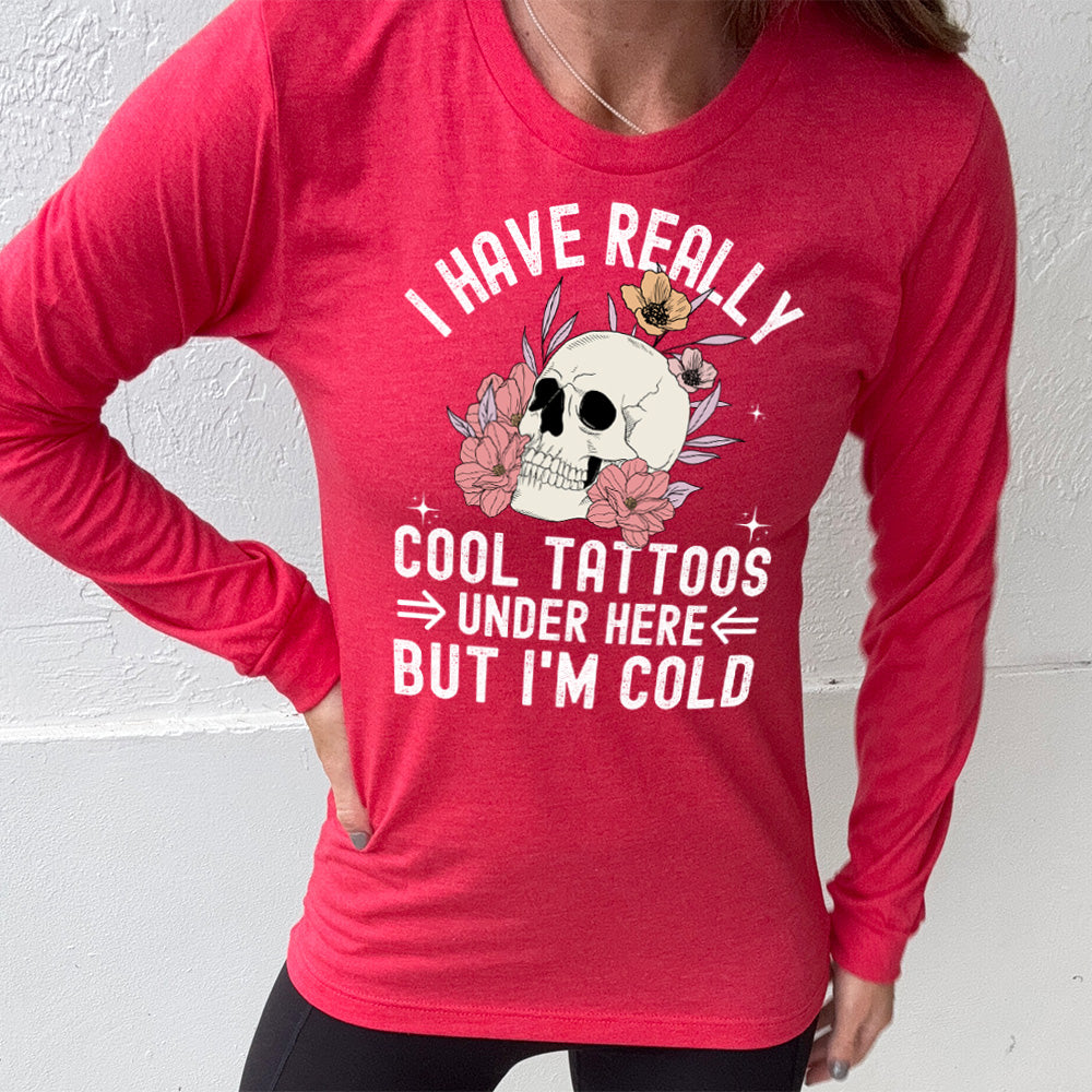 heather red long sleeve with the words "I have really cool tattoos under here but I'm cold" with the image of a skull in flowers