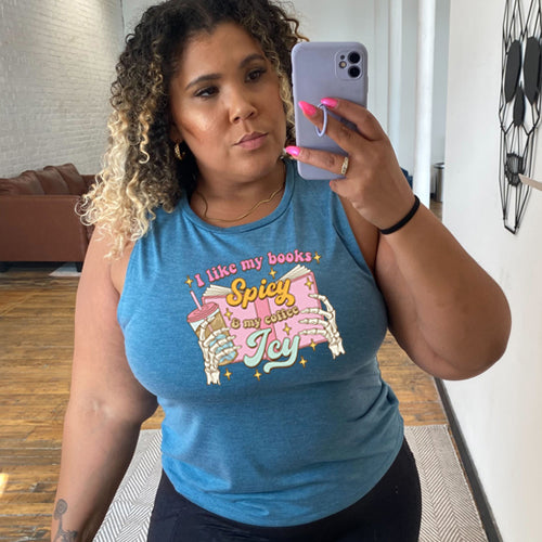model wearing a blue muscle tank top with the saying "I Like My Books Spicy And My Coffee Icy" on it