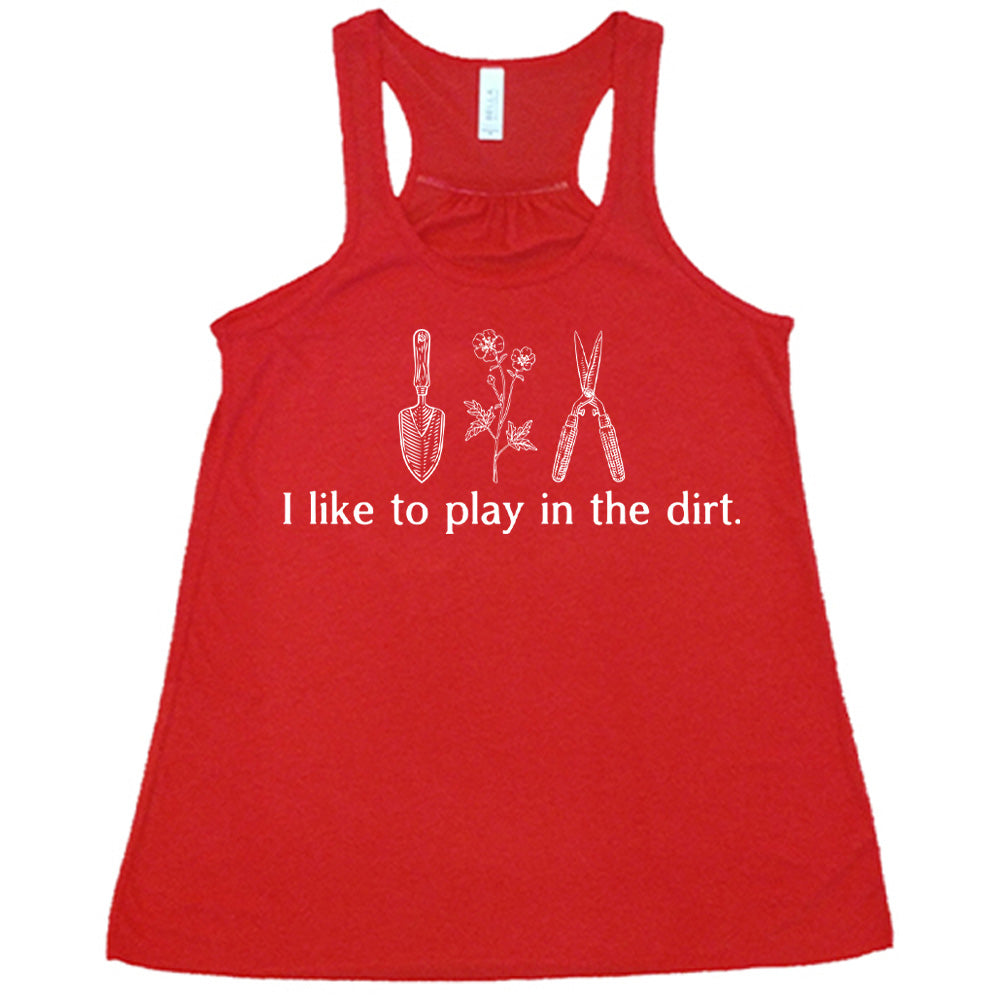 red flowy racerback tank with the words "I like to play in the dirt." on it with the graphic of a hand trowel, two flowers, and shears