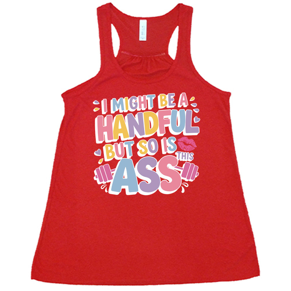 red flowy tank with the words "I might be a handful but so is this ass" in a colorful font, with a barbell as part of the word "ass", and a few little hearts and a kissing lips graphic