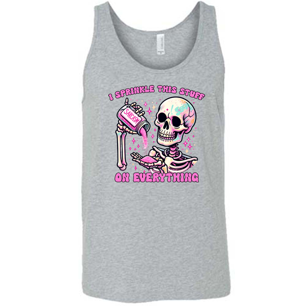 grey unisex tank with the words "I sprinkle this stuff on everything" on it, and the graphic of a skeleton who is pouring a jar labeled "sarcasm" filled with pink glittery material into its hand, surrounded by little pink and white stars